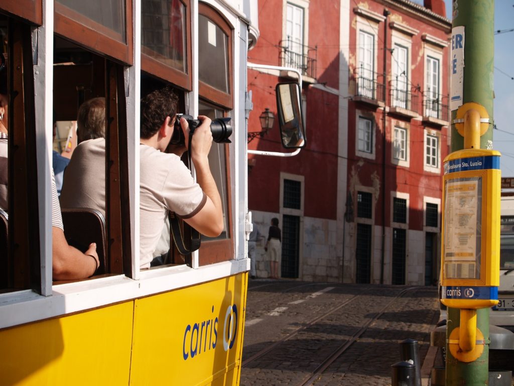 tourist taking pictures in a lisbon tram